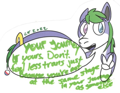 Tanby, the group mascot, a purple alien creature with green hair, smiles and flashes the peace sign!